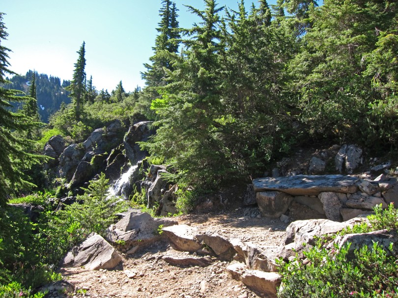 Stone steps and bench at trail switchback overlooking waterfall, Sol Duc Park.
