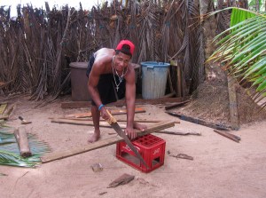 Local young man working at a tourist lodge, barefoot with iPod